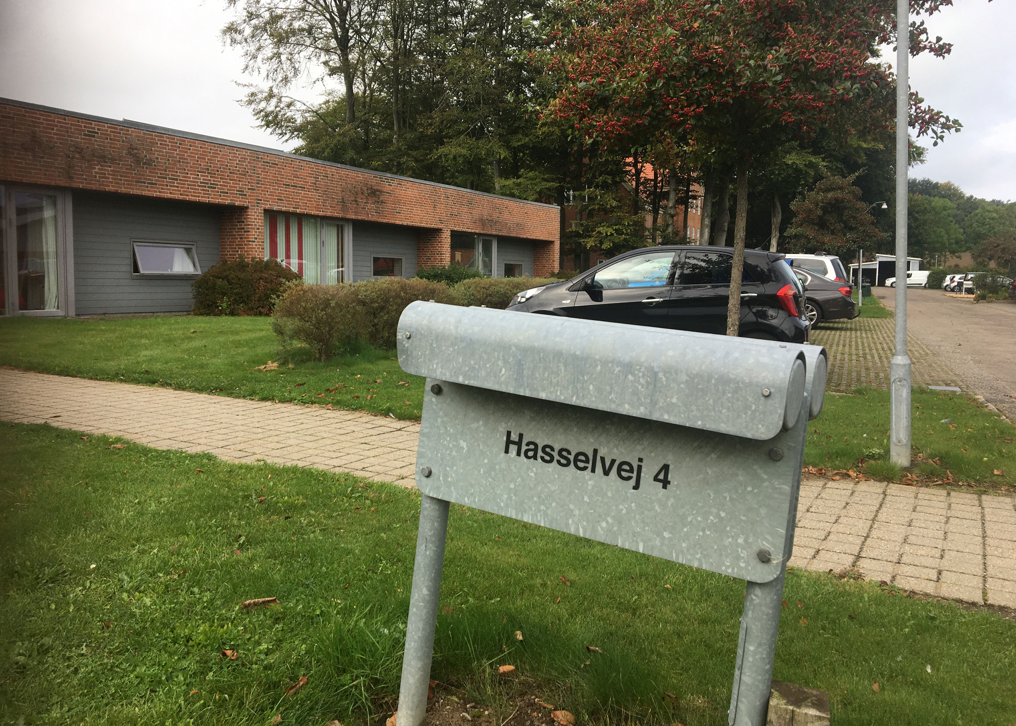 Udenfor ved indgangen står der et gråt skilt hvor der står Hasselvej 4.