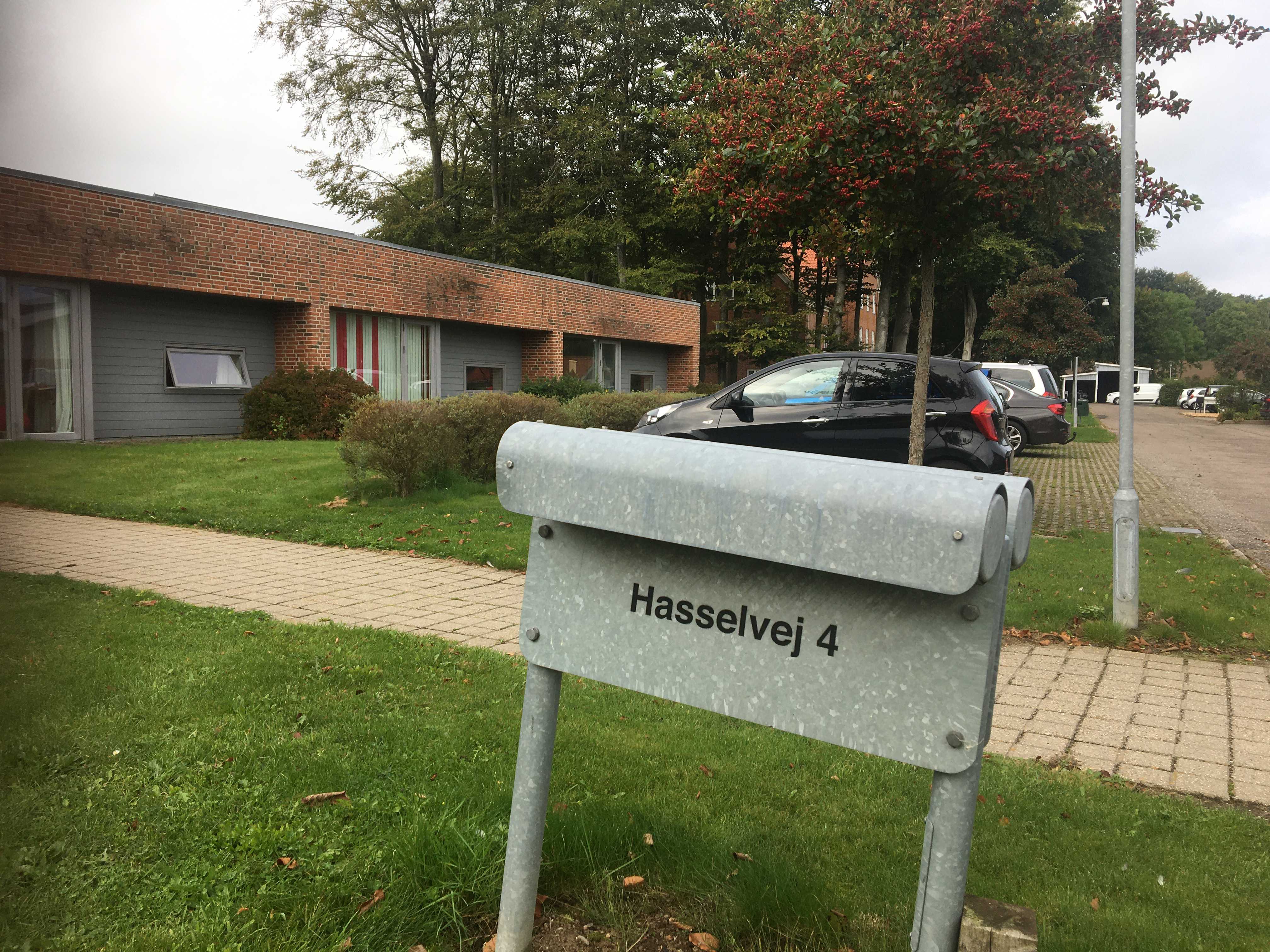 Udenfor ved indgangen står der et gråt skilt hvor der står Hasselvej 4.