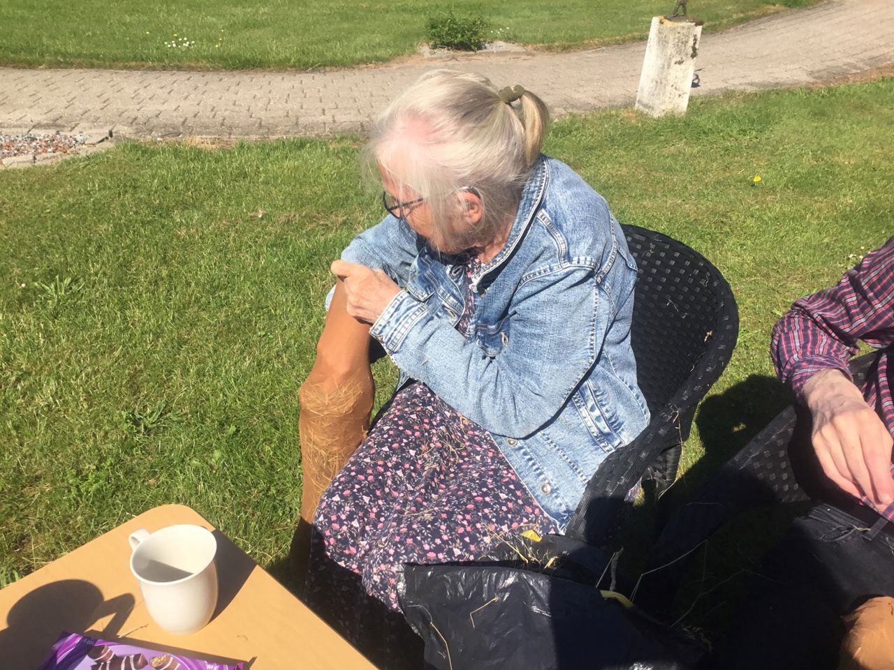 En borger er ved at putte halm i en nylonstrømpe, det er måske en arm eller et ben til en hjemmelavet heks.