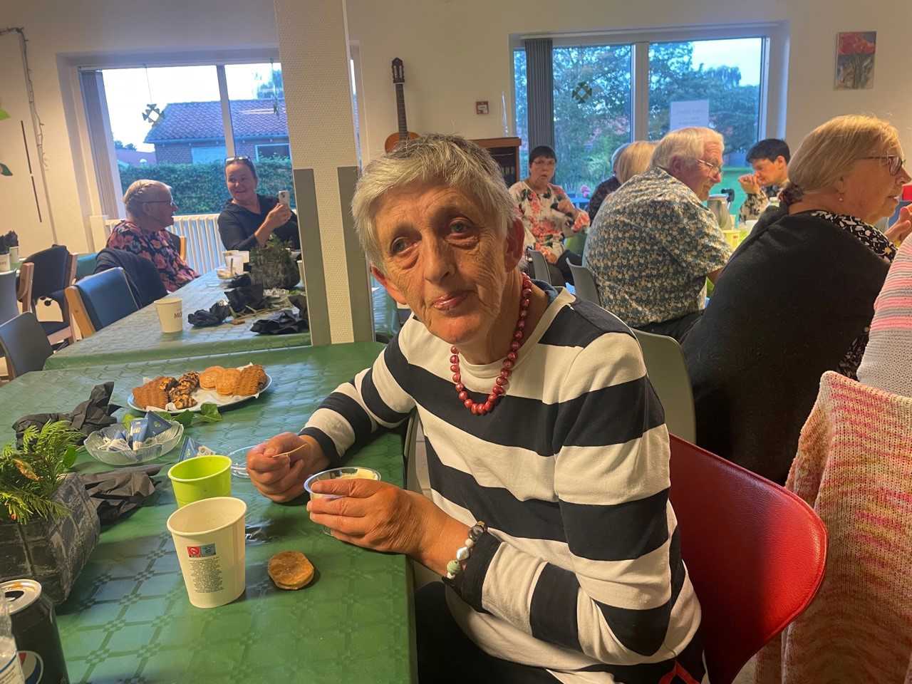 En borger sidder og nyder sin dessert, med en kop kaffe ved et fint dækket bord