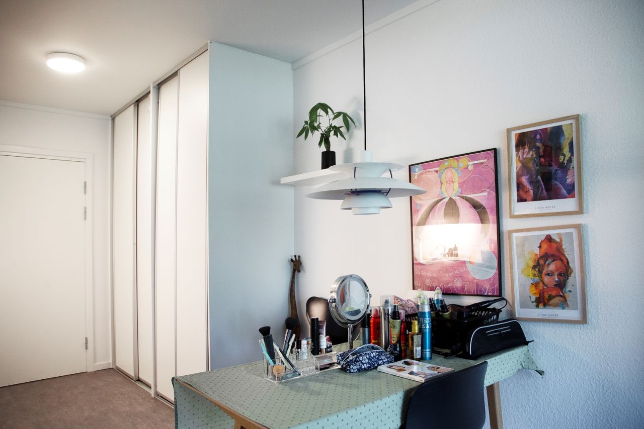 Bord med kosmetik og hårprodukter foran er der et stort skan med fire hvide låger