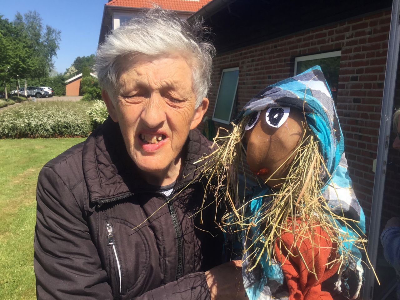 En borger sammen med heksen til bålet, heksen er lavet af halm og tøj og har et ansigt, med flot rød læbestift.