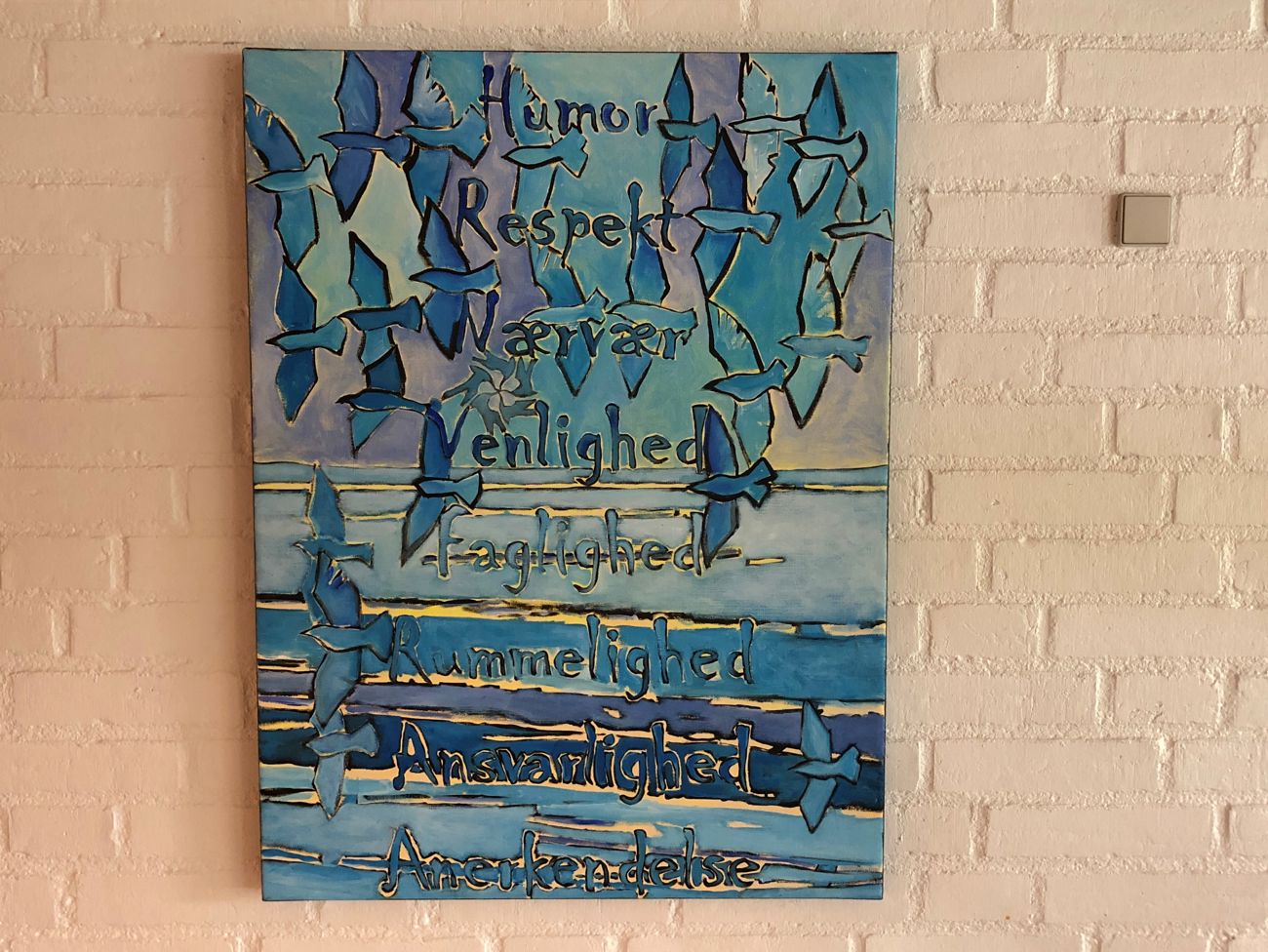 Keramik bilede med skriften: Humor, respekt, nærvær, venlighed, faglighed, rummelighed, ansvarlighed og anerkendelse.