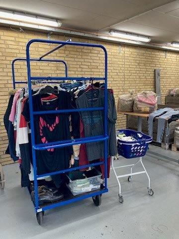 Der står et stort stativ med tøj der skal gennemgås inden det skal sættes til salg i 2nd. Hand butikken.