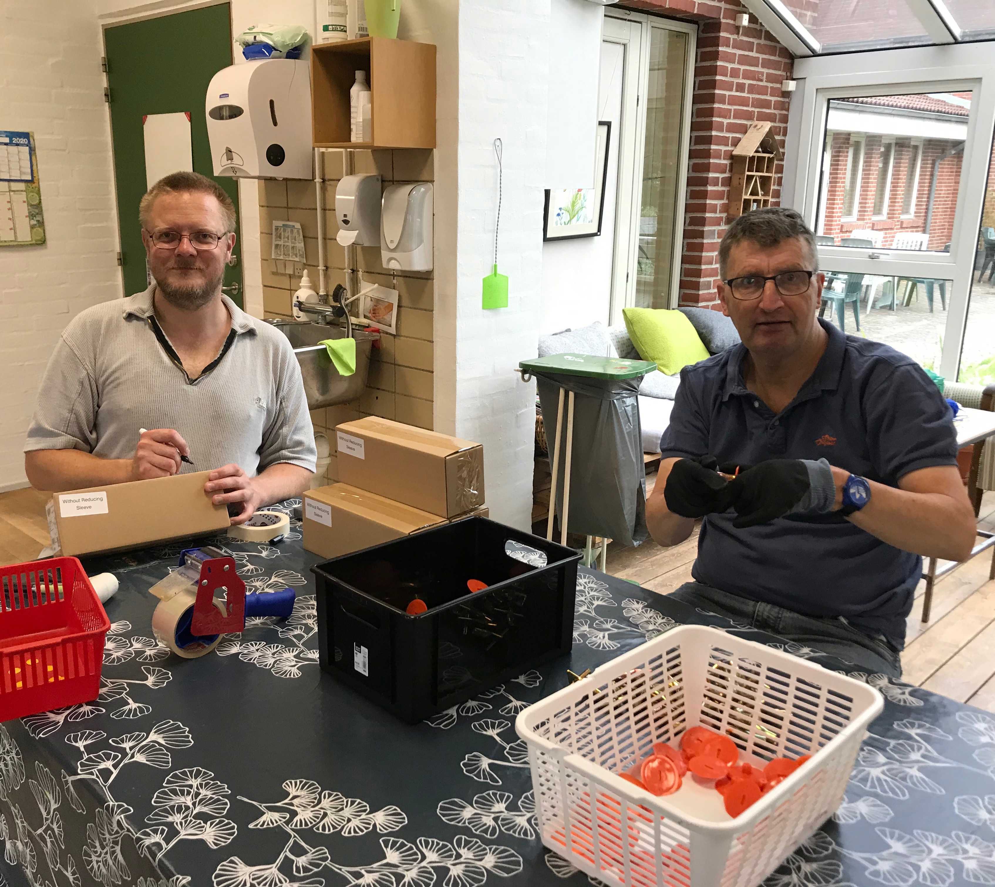 Der er to borger den ene er ved og pakke og den anden sidder og samler små plastting