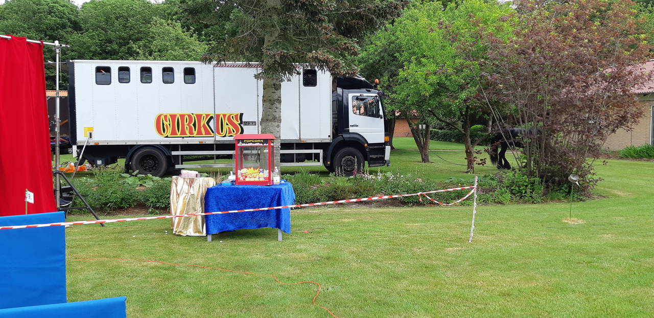 Cirkusvogne og popcorn maskine er stillet op i haven