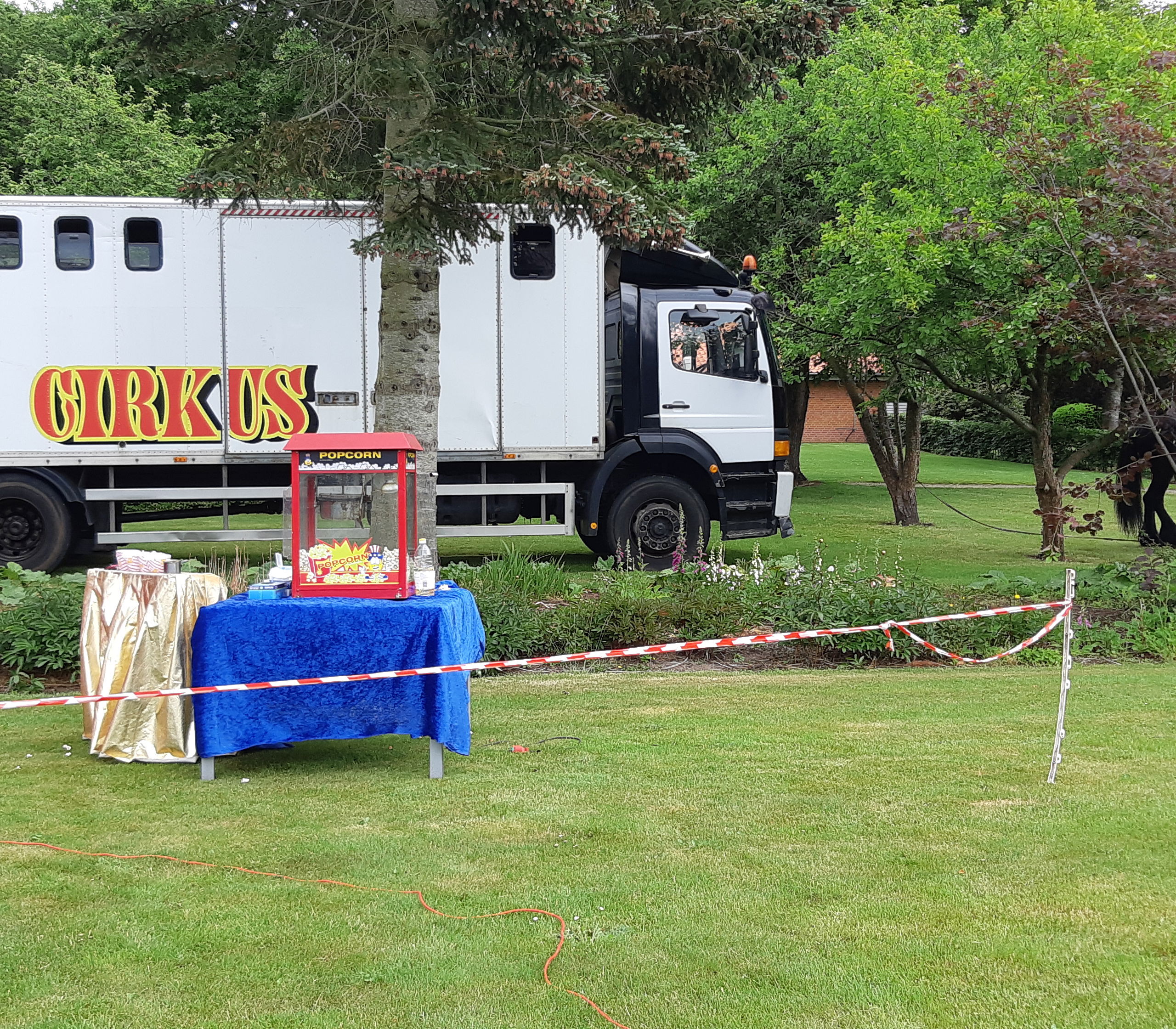 Cirkusvogne og popcorn maskine er stillet op i haven