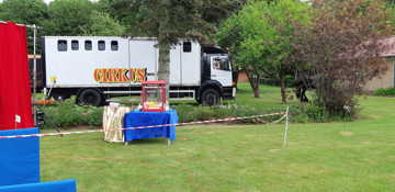 Cirkusvogne og popcorn maskine er stillet op i haven