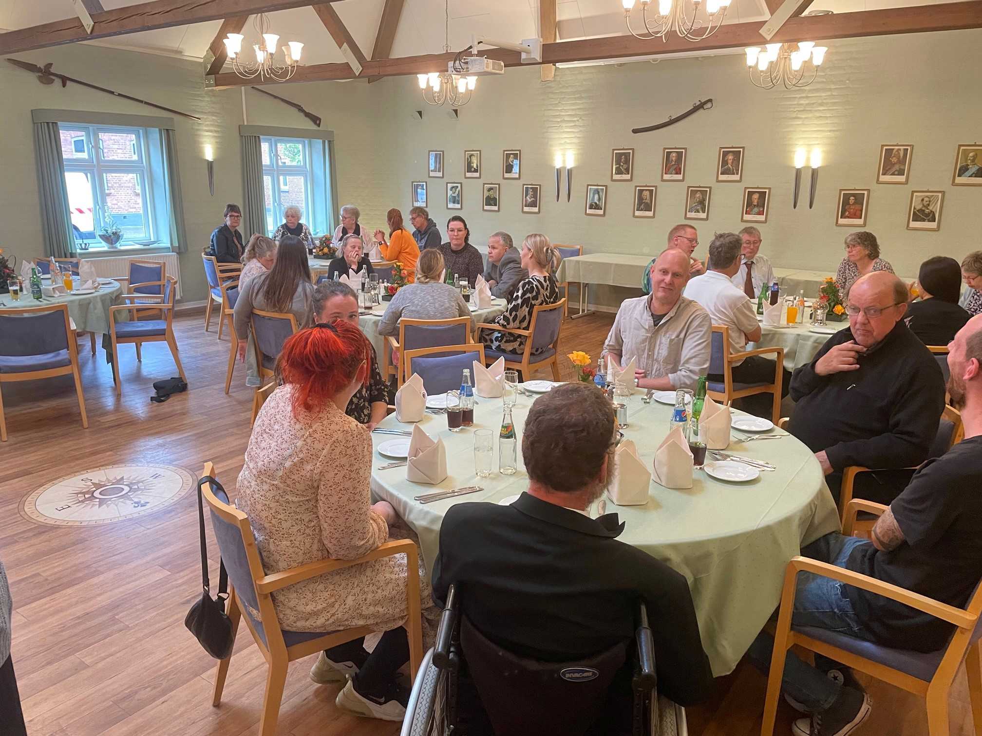 Alle sidder ved runde borde og spiser og snakker