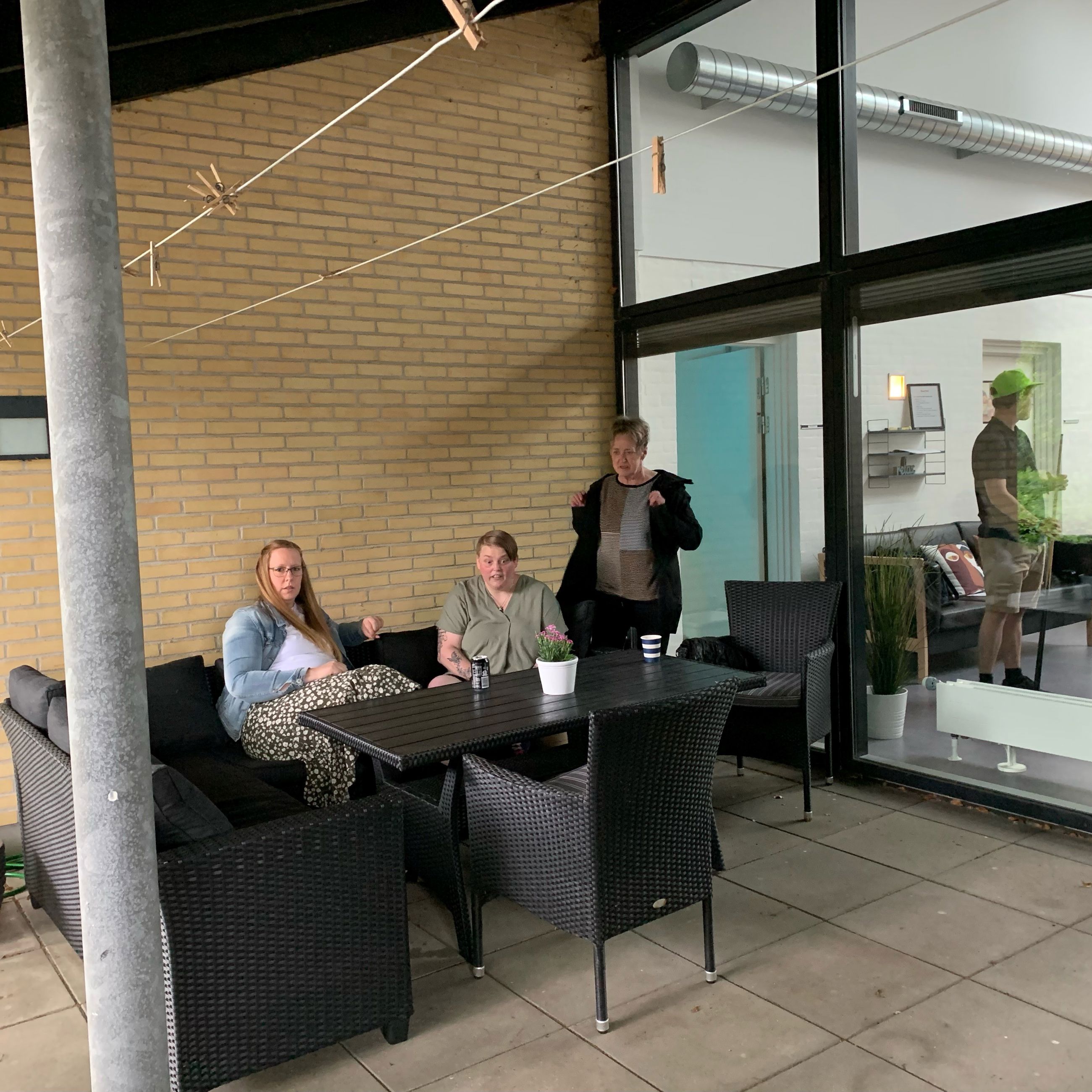 3 personer sidder ved et havebord på en overdækket terasse på Bargumsvej