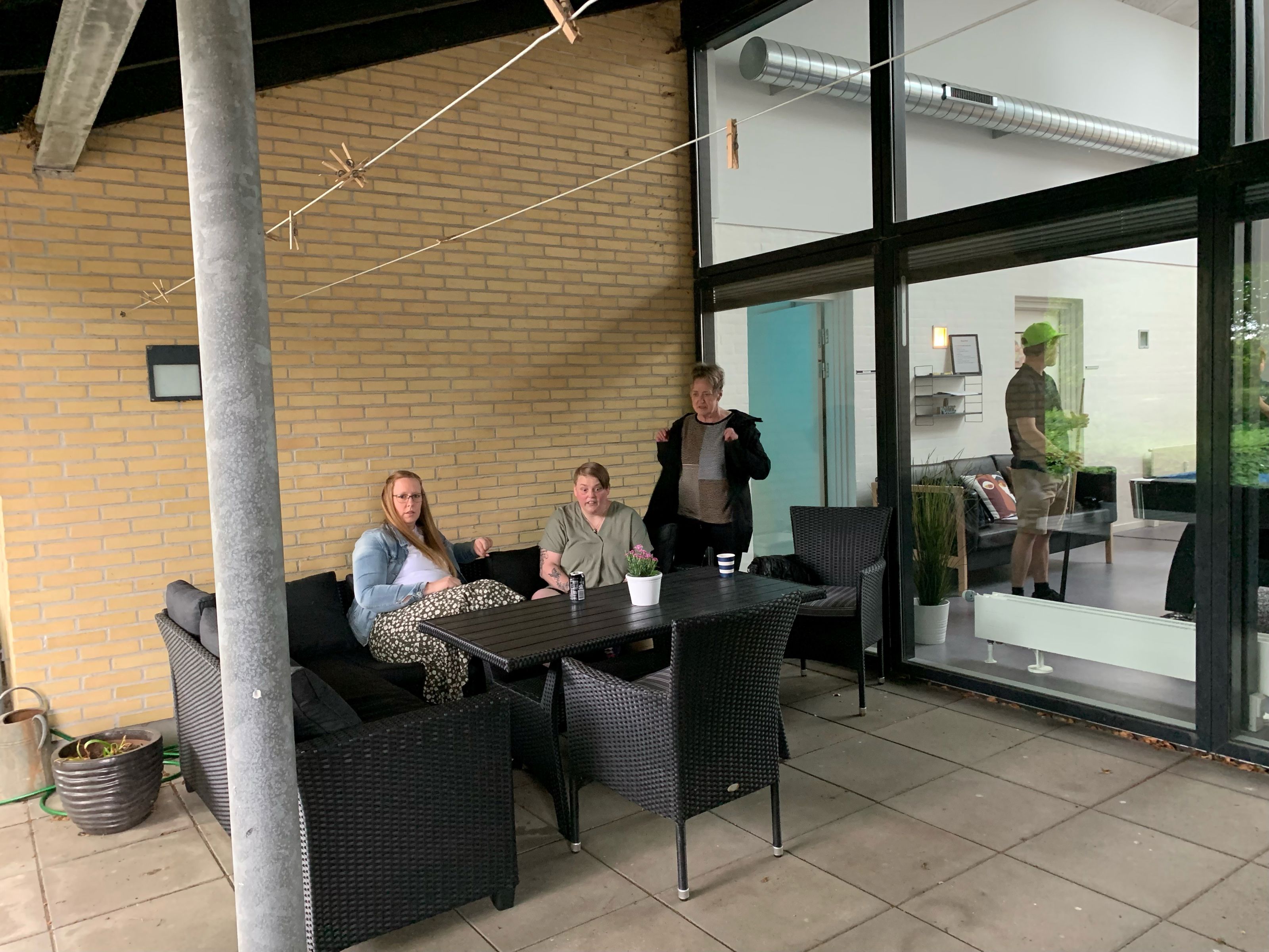 3 personer sidder ved et havebord på en overdækket terasse på Bargumsvej