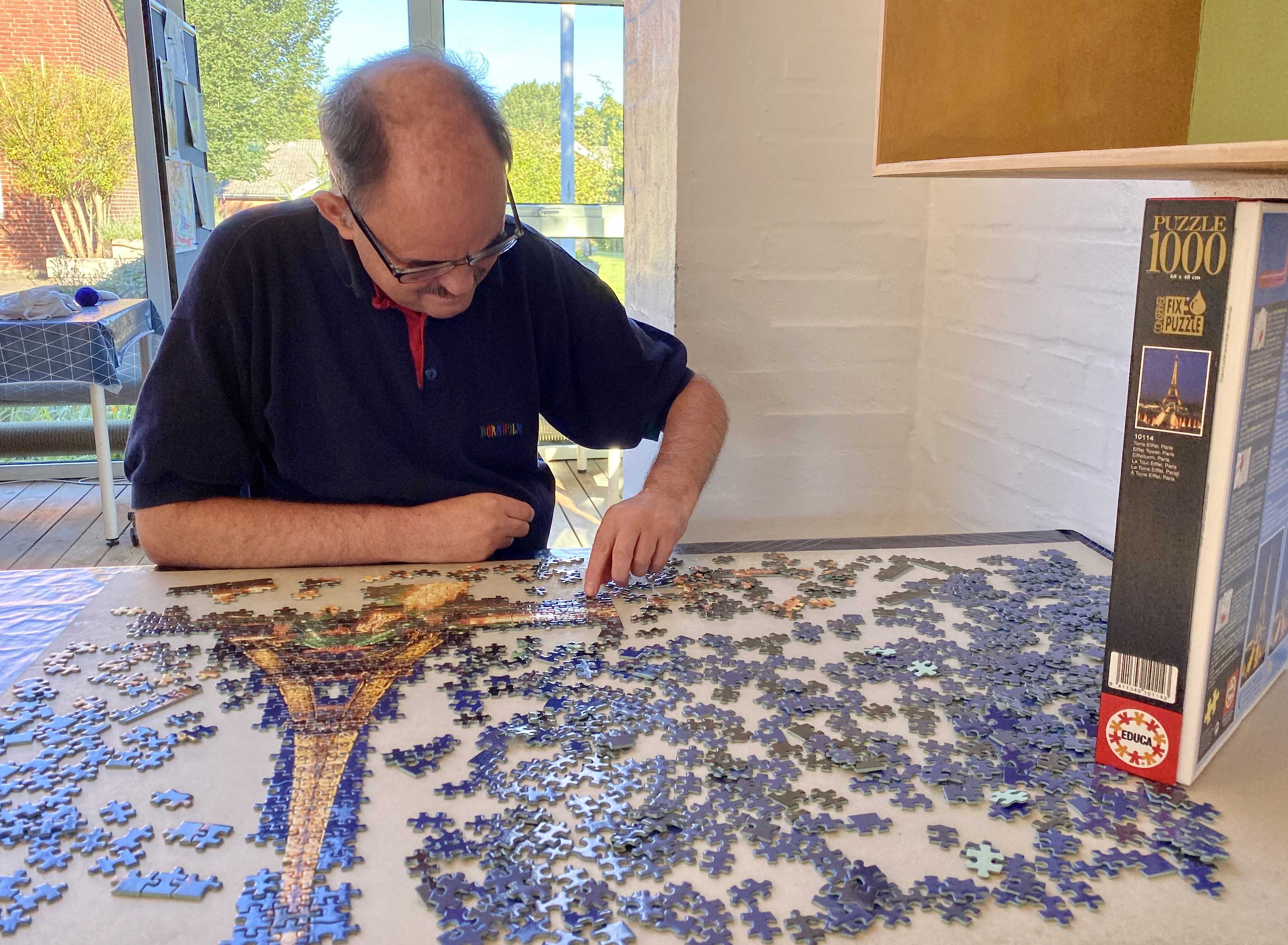 En borger sidder og lægger et puslespild på 1000 brikker.