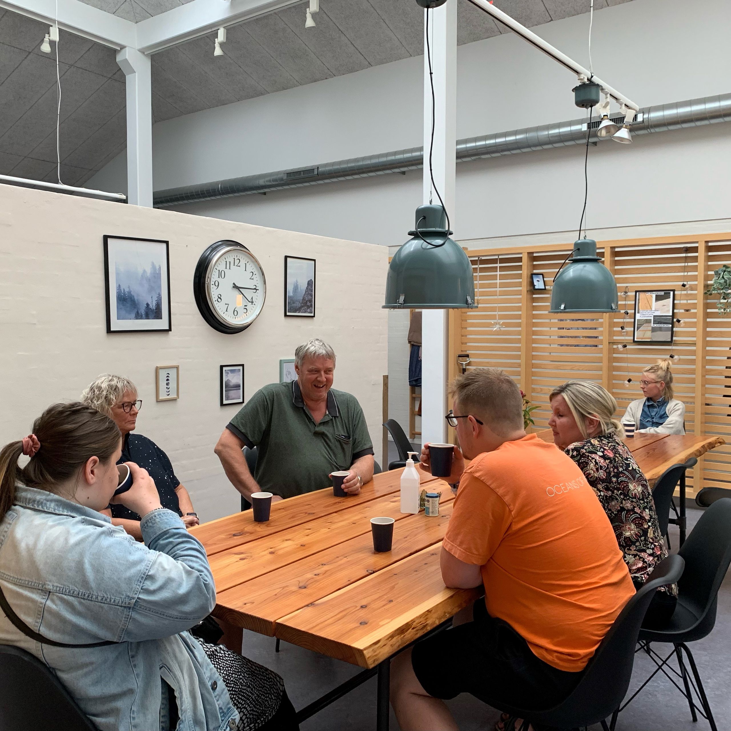 Der hygges indenfor på Bargumsvej, der sidder 6 personer ved et spisebord og snakker