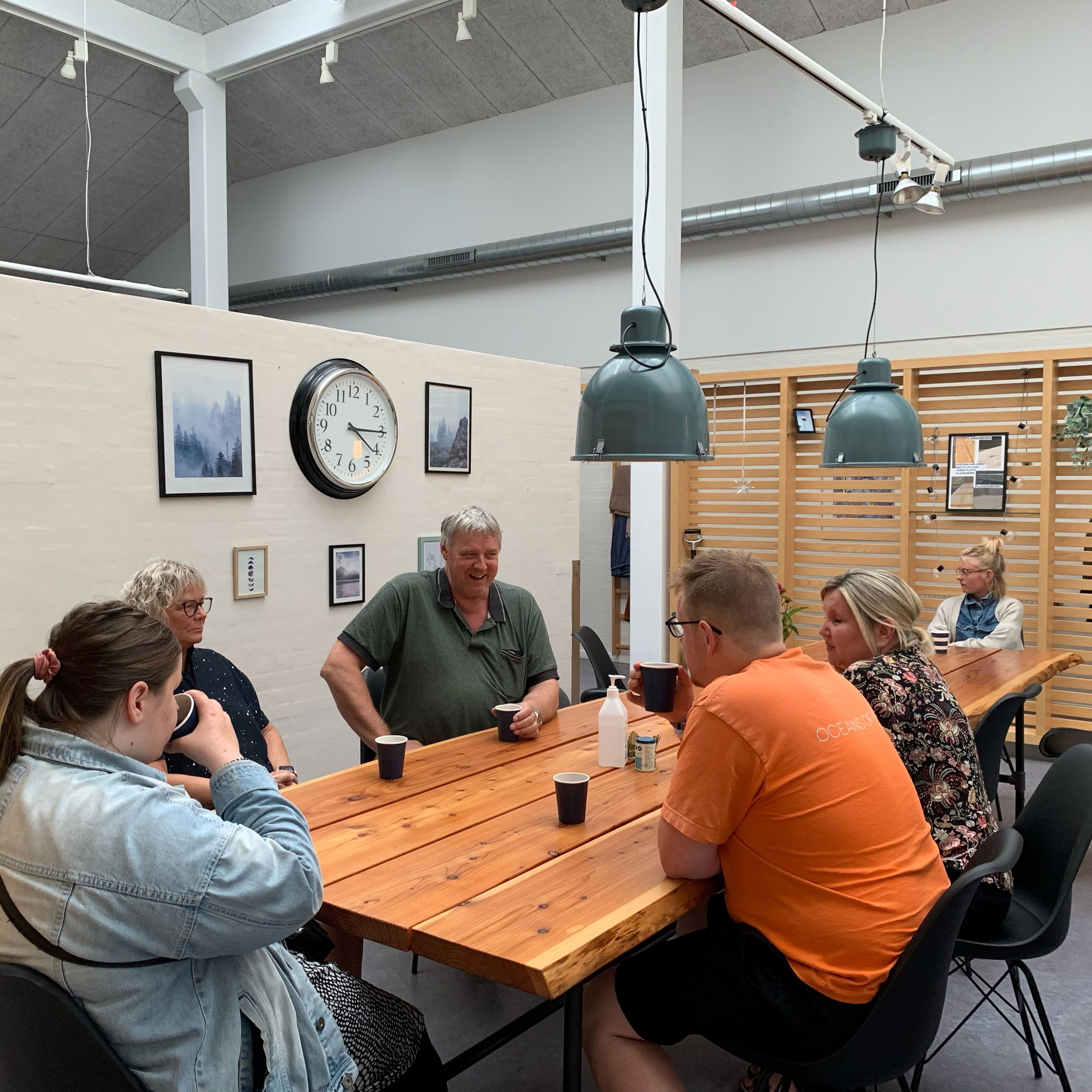 Der hygges indenfor på Bargumsvej, der sidder 6 personer ved et spisebord og snakker