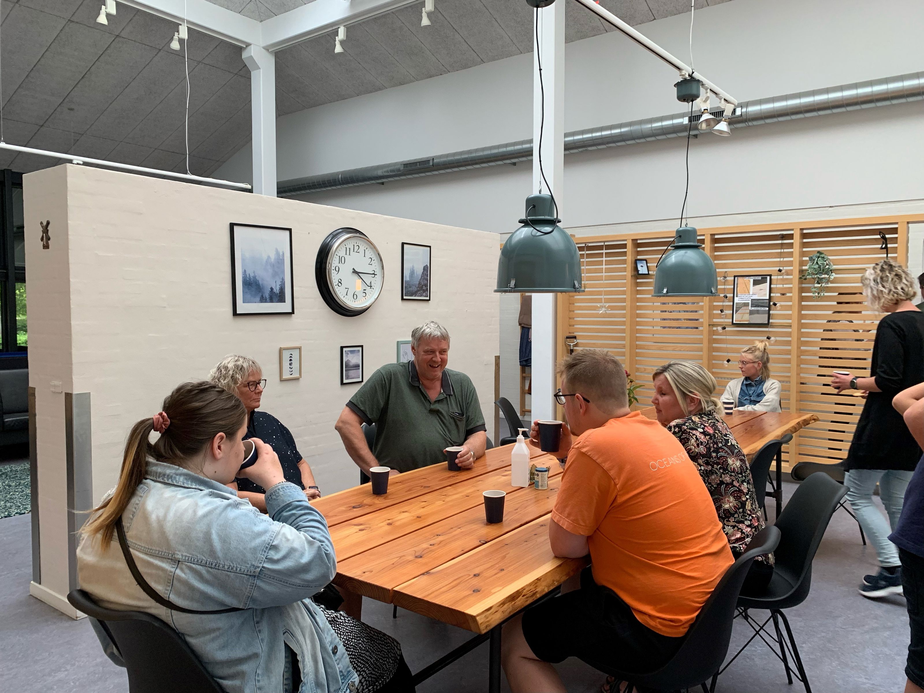 Der hygges indenfor på Bargumsvej, der sidder 6 personer ved et spisebord og snakker