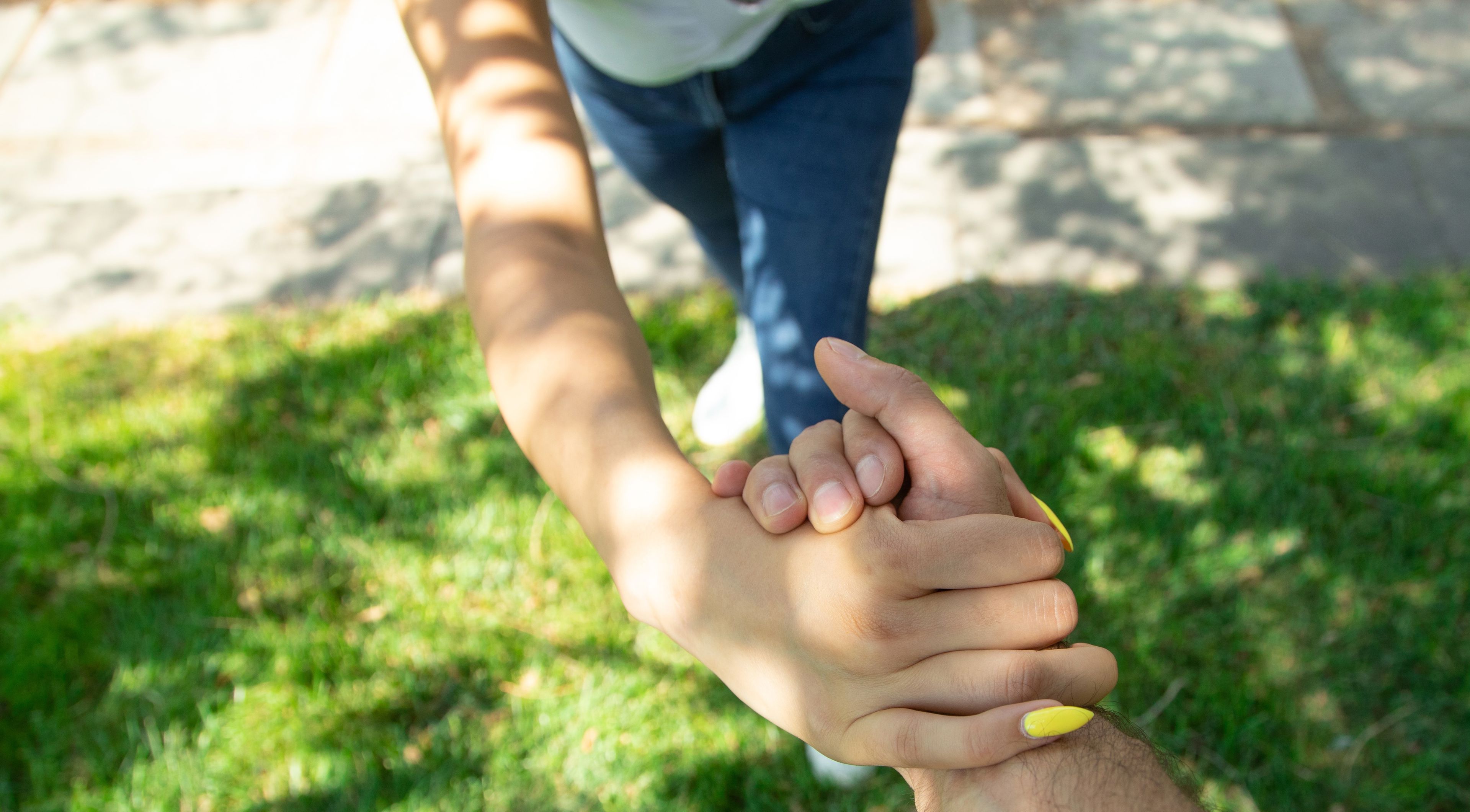 Billede af en mand og en kvinde arm, der holder hinanden ved håndledet.