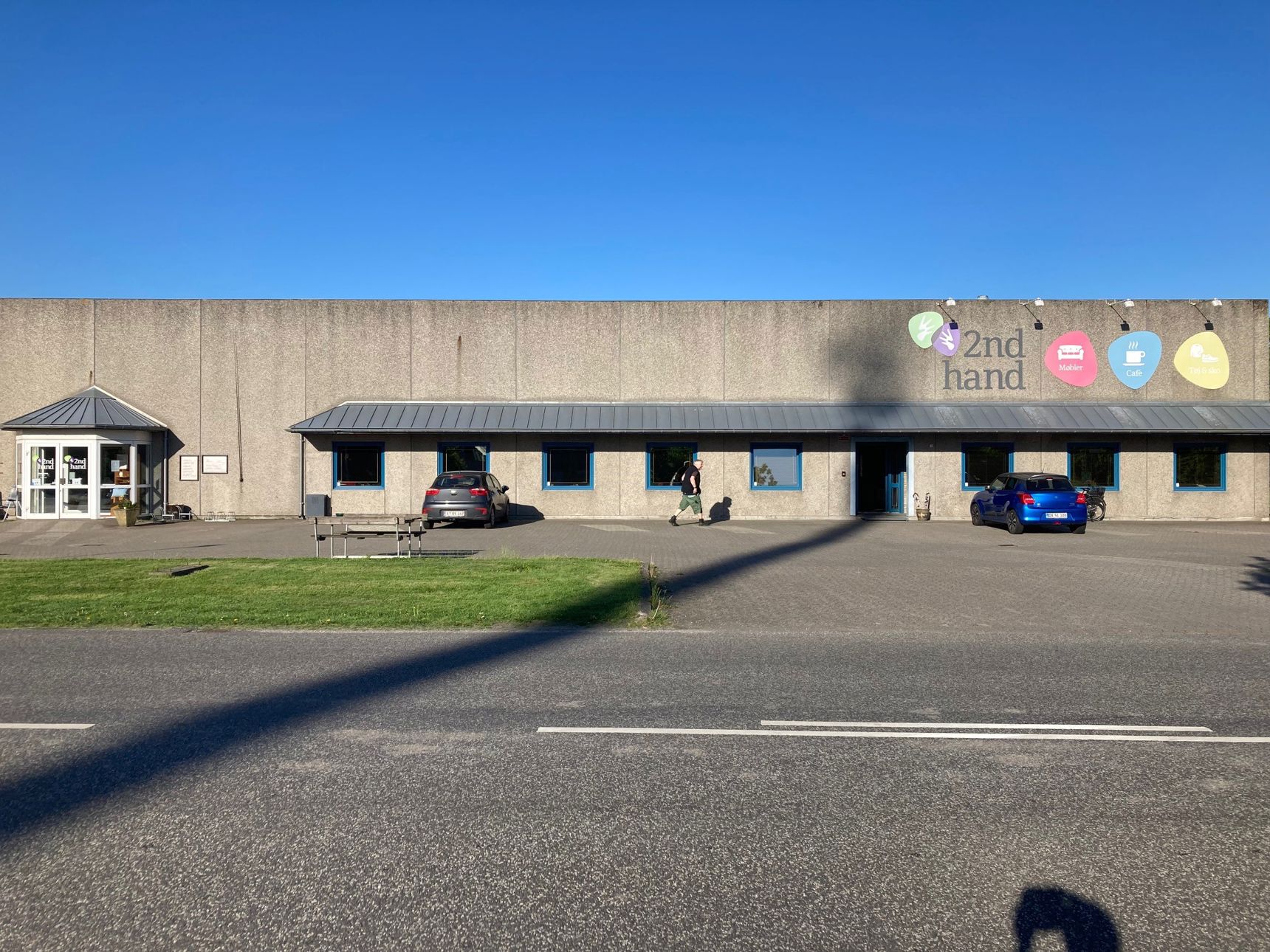 Oversige over 2Nd Hand butikken udefra man kan se skiltene i forskellige farver med tekst på