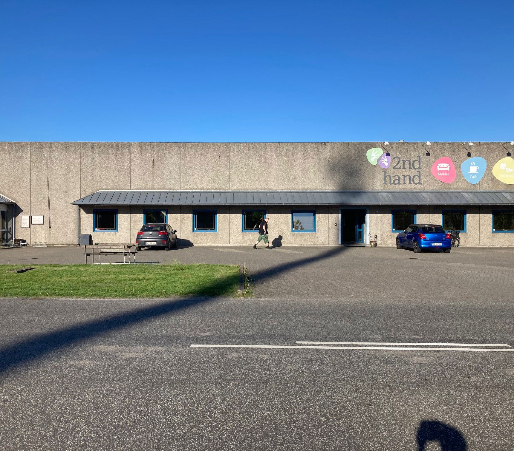 Oversige over 2Nd Hand butikken udefra man kan se skiltene i forskellige farver med tekst på