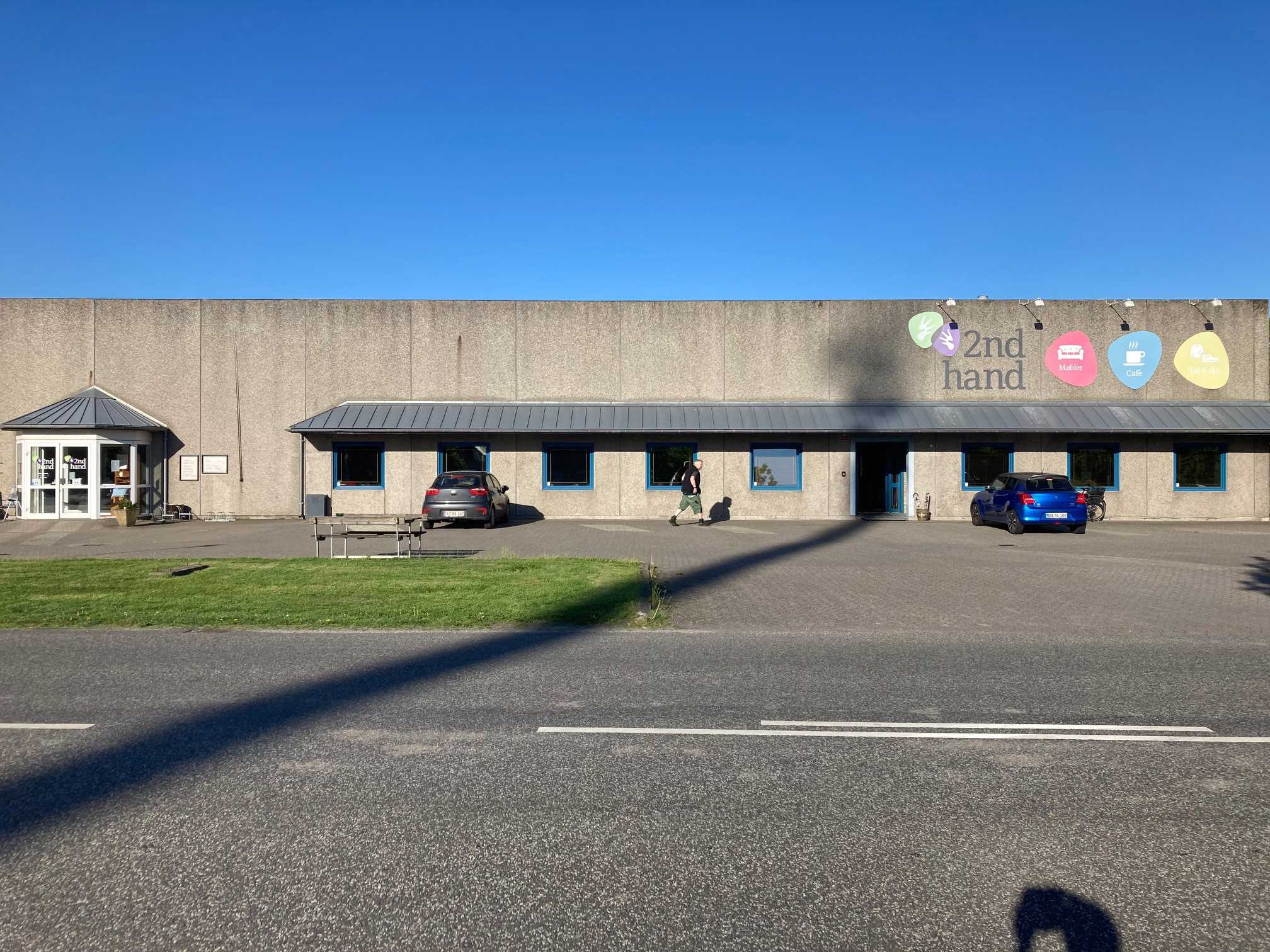 Oversige over 2Nd Hand butikken udefra man kan se skiltene i forskellige farver med tekst på