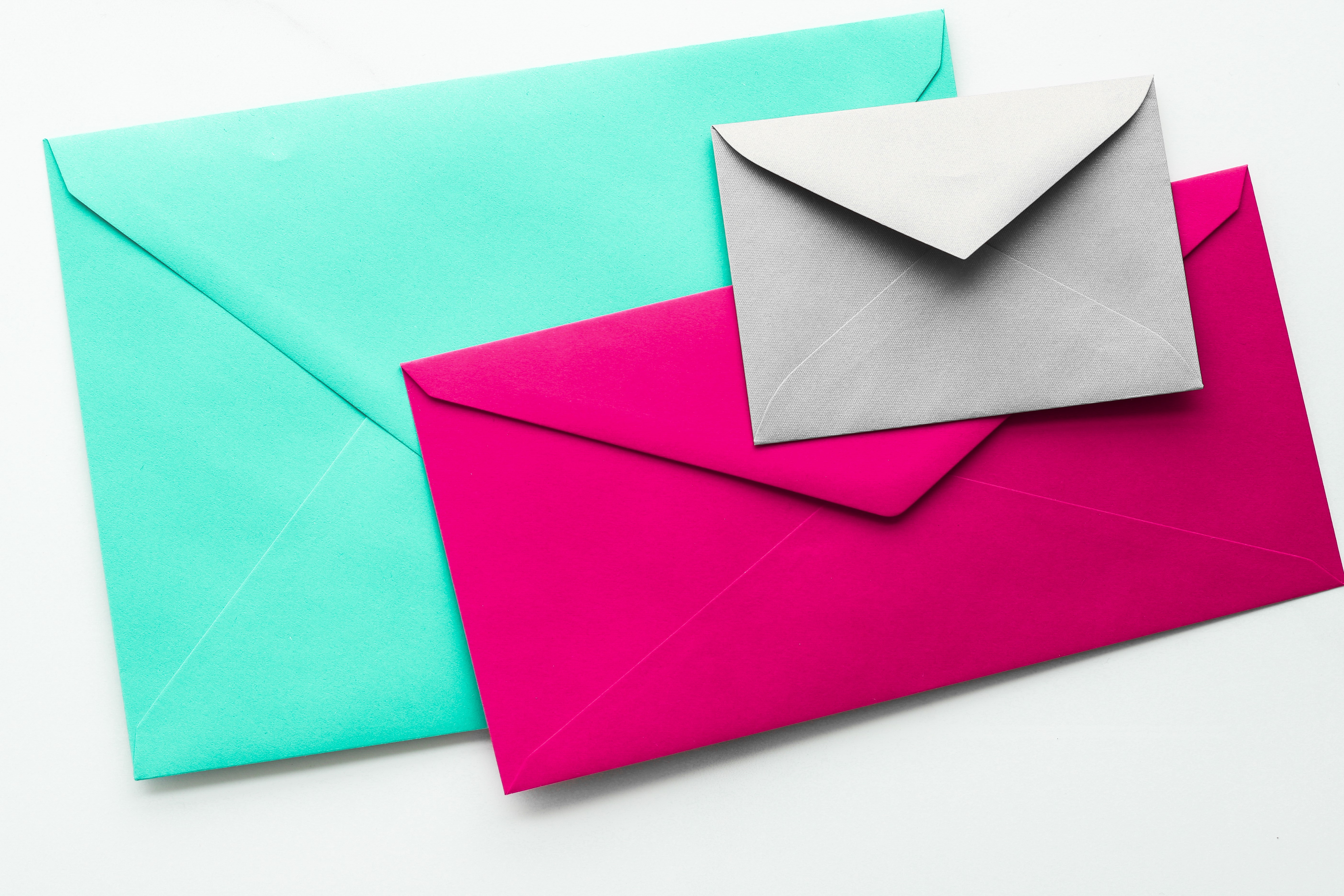 Billede af tre kuverter i forskellige størrelser og farver.